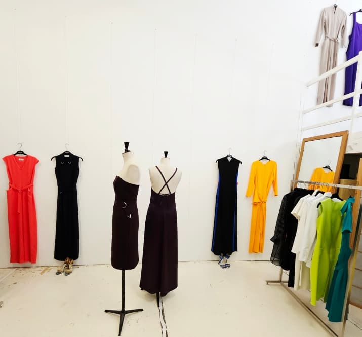 L'atelier Petrovitch and Robinson — pièces de la collection suspendues aux murs clairs et présentées sur mannequins